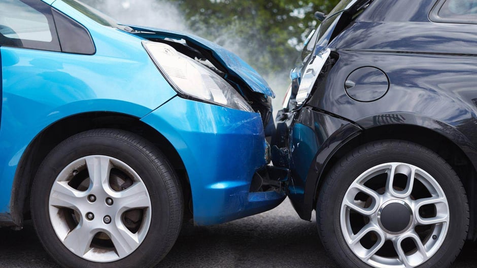 A rear end collision that has occurred between a blue car and a black car in Alabaster, Alabama